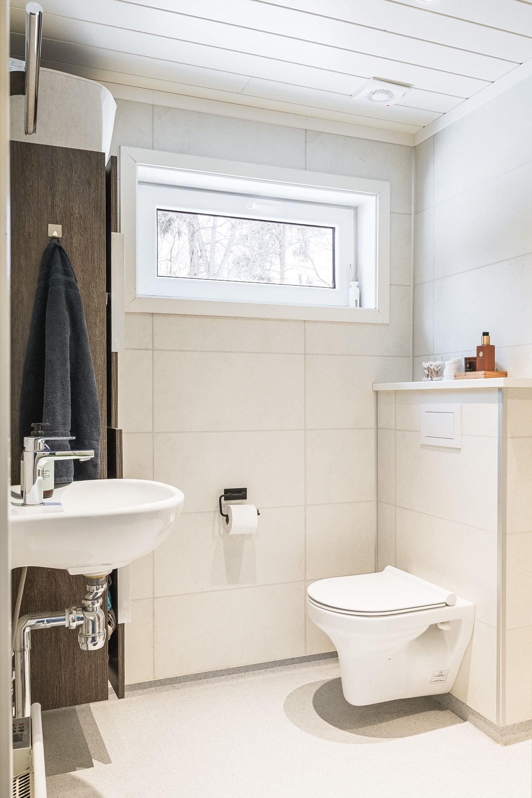 Baderommet er utstyrt med vegghengt servant med rundt speil over, høyskap med god oppbevaringsplass og vegghengt toalett, samt dusjnisje. Galleribilde