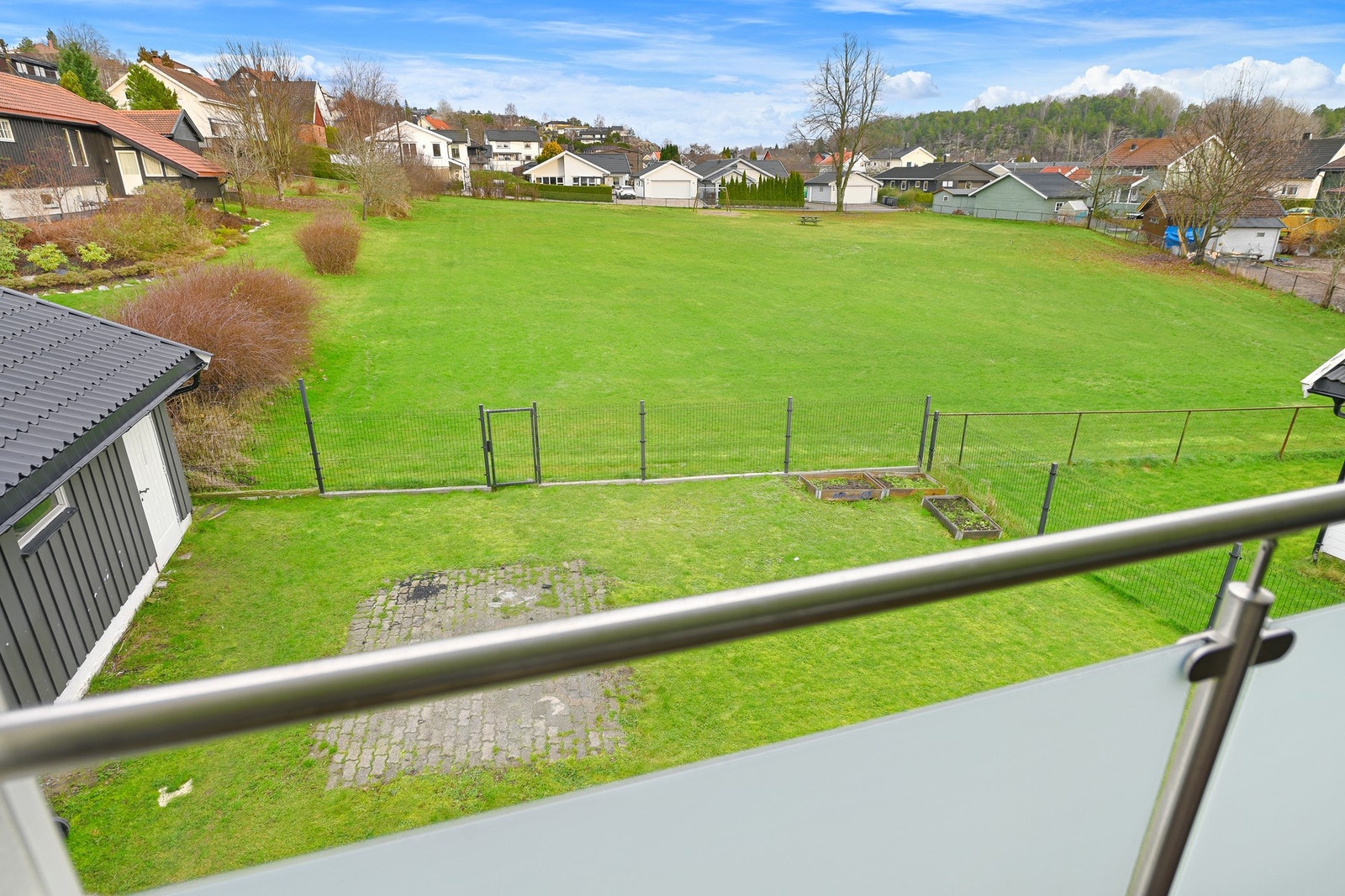 Inntil eiendommen er det et stort kommunalt grøntområde med lekeplass. I gjerdet er det satt inn port. Galleribilde