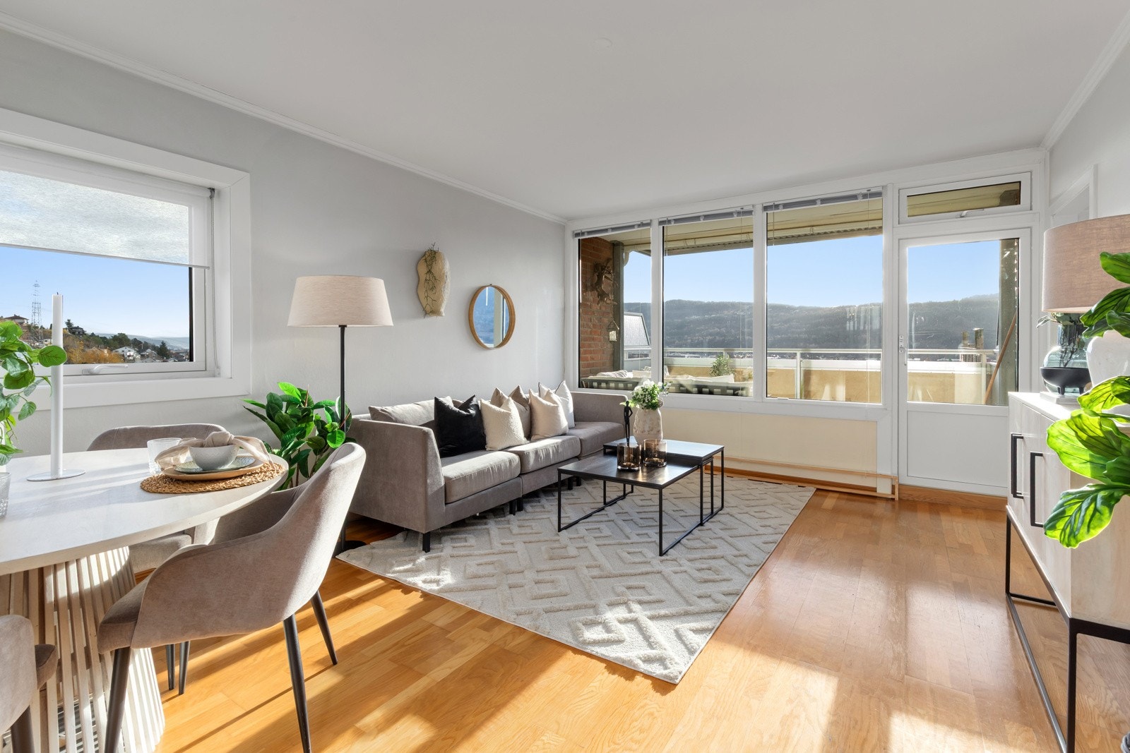 Stue med god plass til spisestue | endevindu mot øst og store panoramavinduer mot sør gir masse lys og sol inn (solskjerming) Galleribilde