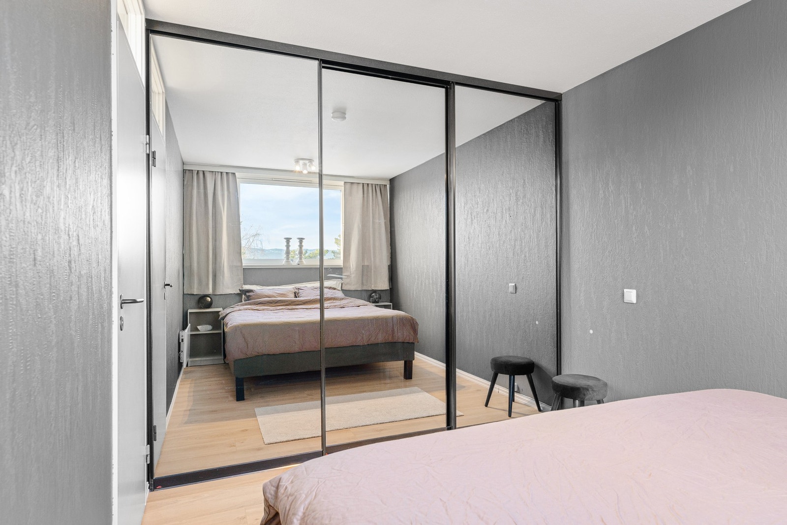 Lekkert veggmontert garderobeskap med speil i skyvedørs løsning. Galleribilde