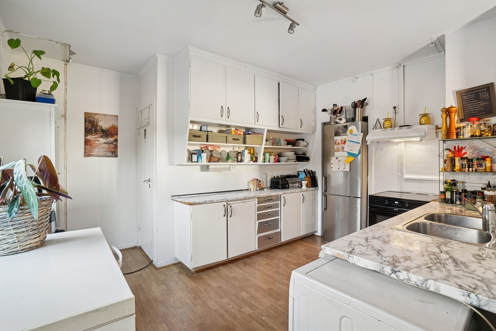 Kjøkkenet er utstyrt med kjøl/fryseskap, komfyr med platetopp og opplegg for vaskemaskin. Hvitevarer kan kjøpes ved behov. Kjøkkenet er med hvite slette fronter, laminert benkeplate og oppvaskkum. Galleribilde