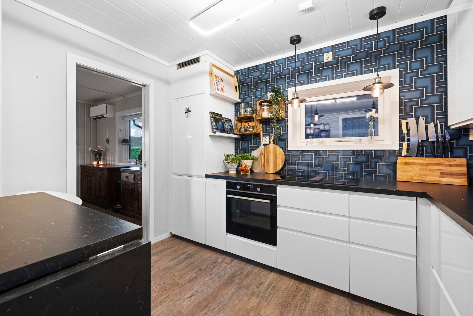 Lys kjøkkeninnredning med mye skap og benkplass. Galleribilde