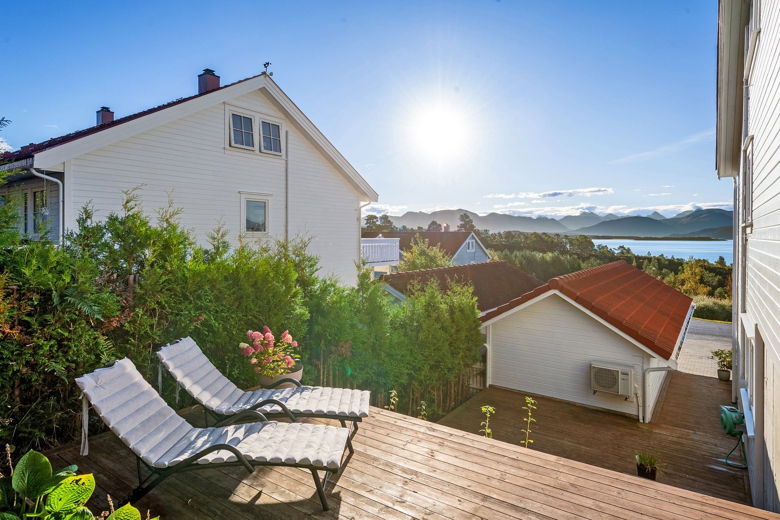 Foran boligen har man plen og rundt boligen mot baksiden er det fint opparbeidet med terrasser på ulike nivå Galleribilde