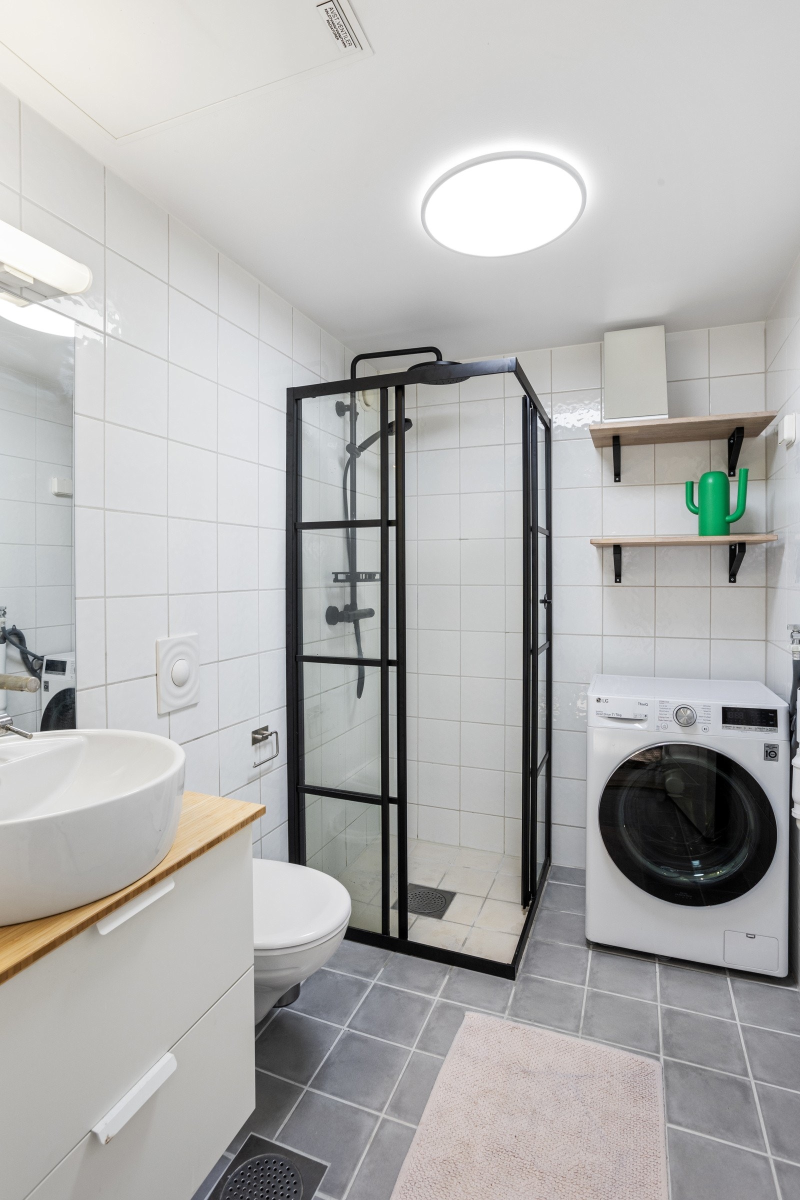 Badet har flislagt gulv/vegger, gulvvarme, dushjørne med dører og dusjarmatur som ble byttet ut i 2024. Galleribilde