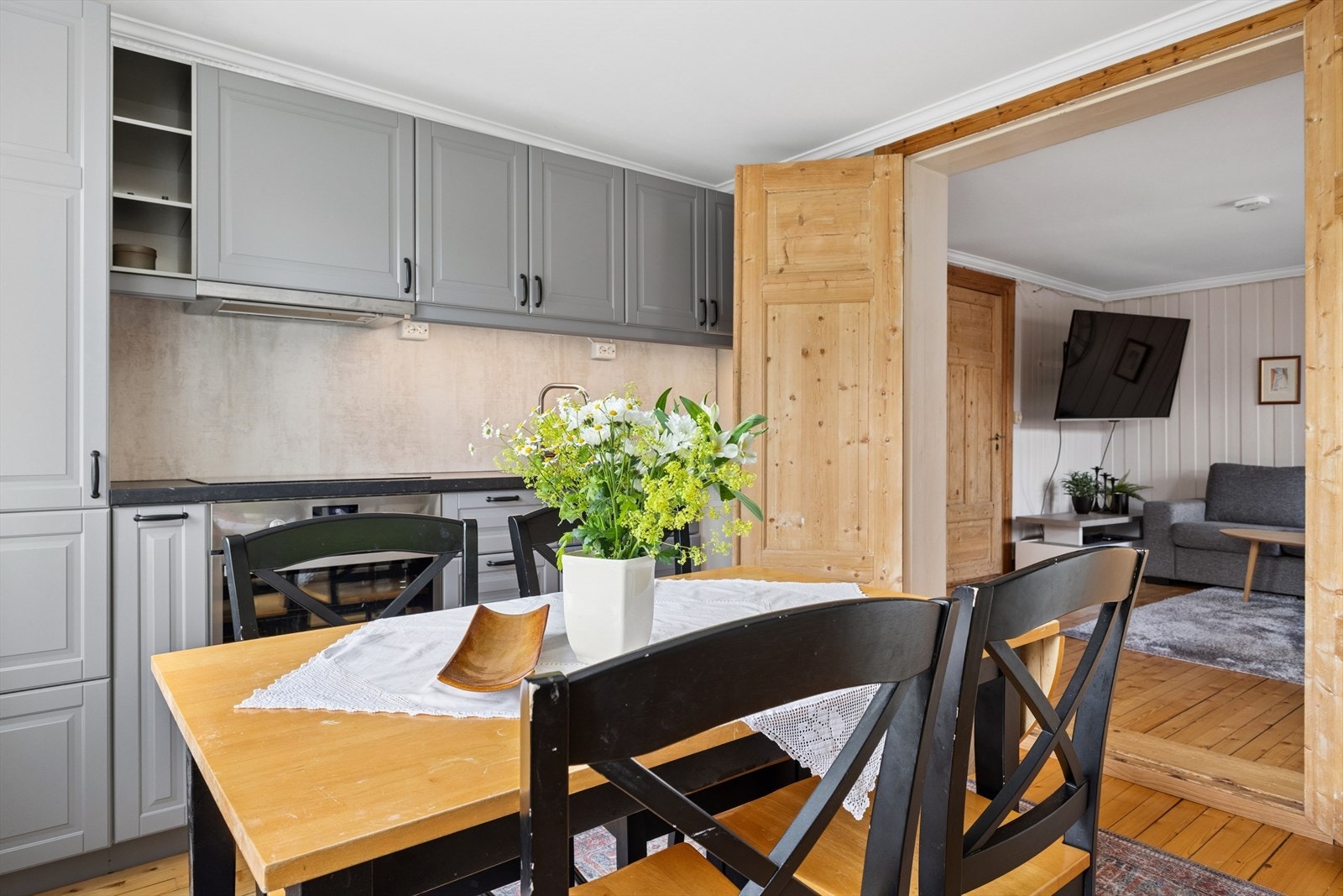 Kjøkkenet har en romslig åpning mot stuen, som gir en naturlig og sosial flyt mellom oppholdsrommene. Her kan du lage mat samtidig som du er en del av samtalen i stua. Galleribilde