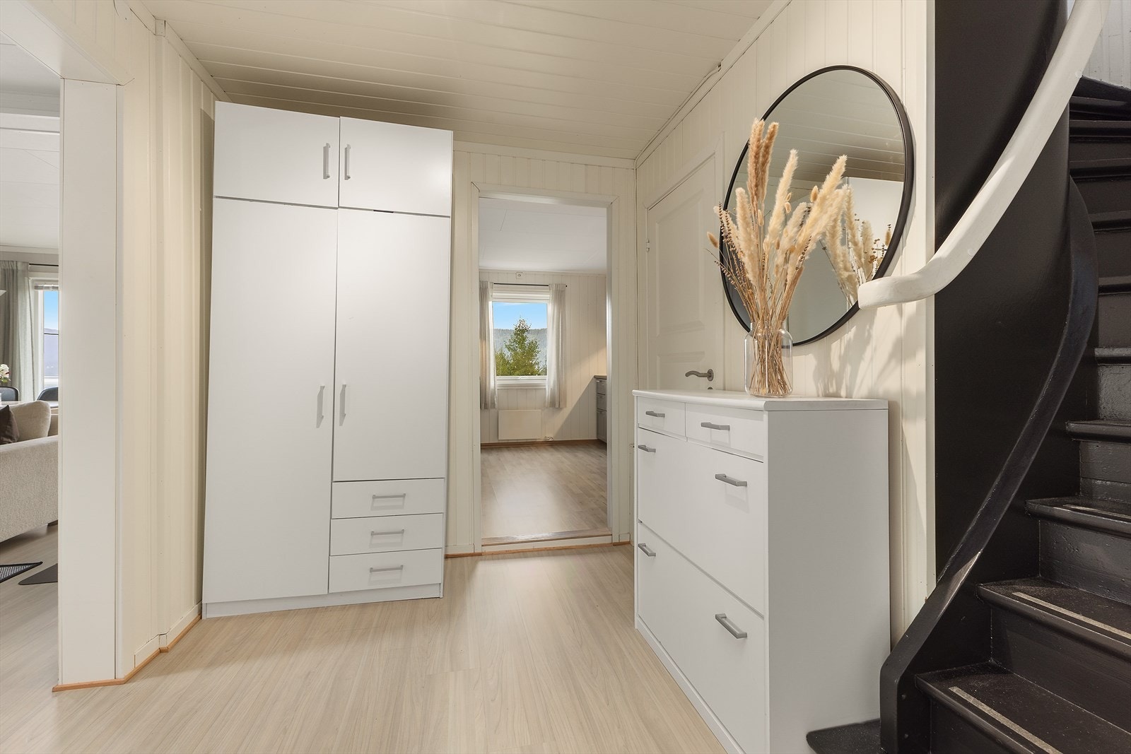 Velkommen inn! Her møtes du av en romslig hall som gir videre adkomst til kjøkken og stue. Under trappen til loftsetasjen er en praktisk bod. Galleribilde