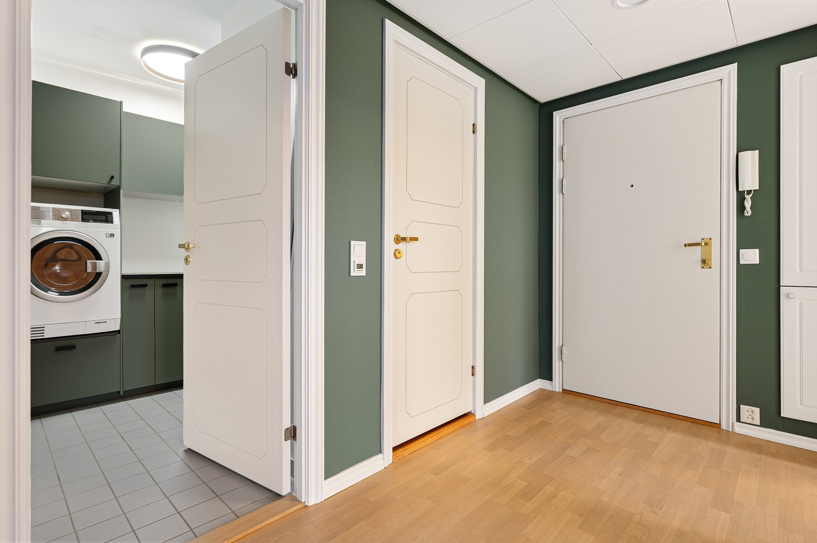 Entré med parkett på gulv, malte vegger og med plass til å henge av yttertøy. Meget praktisk og flott vaskerom som var oppgradert opp for noen år siden. Flott design fra Epoq med grønne fronter, svarte håndtak og svart benkeplate. Galleribilde