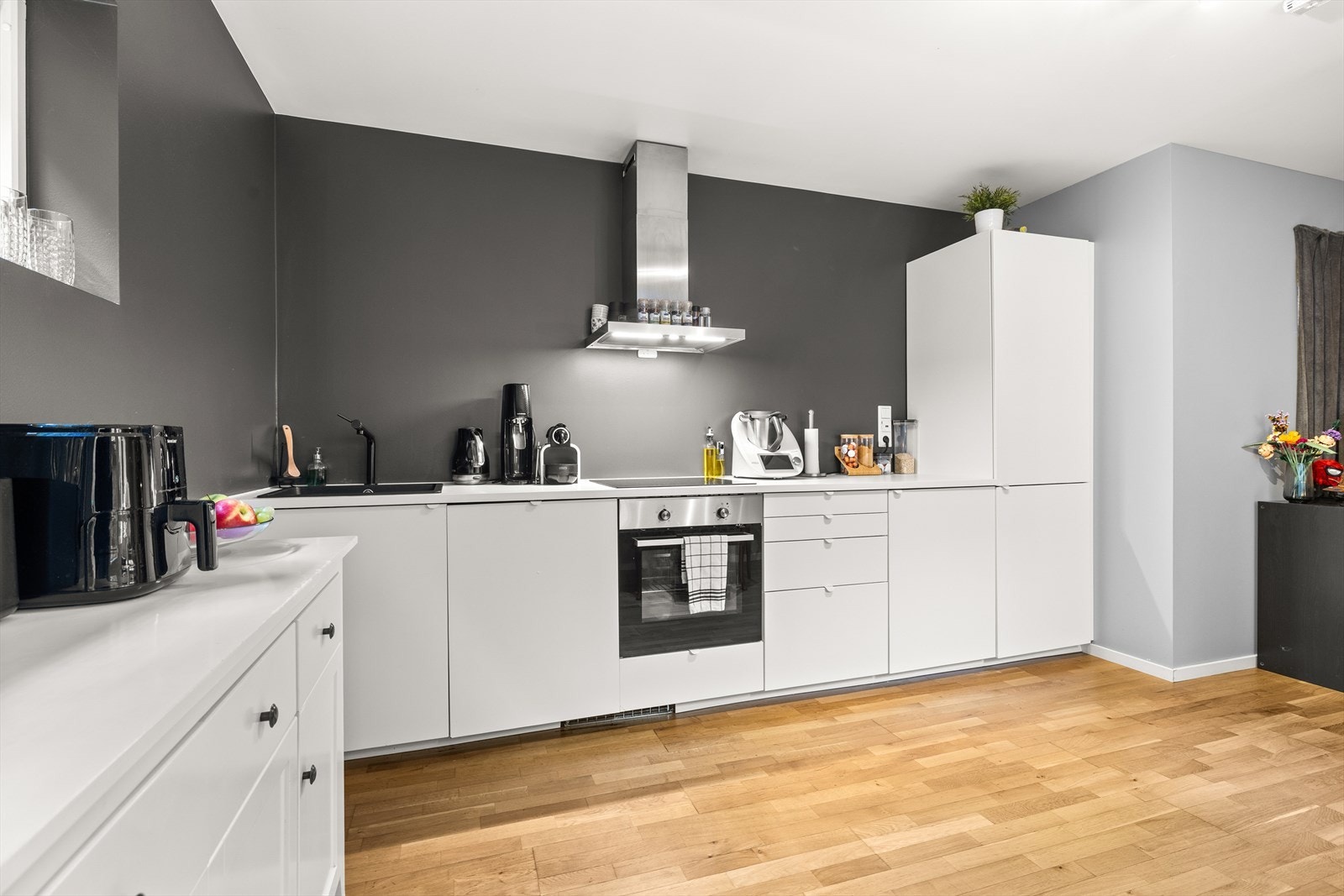 Pent kjøkken fra 2021 med integrerte hvitevarer som komfyr, platetopp, oppvaskmaskin, kjøl/fryseskap Galleribilde