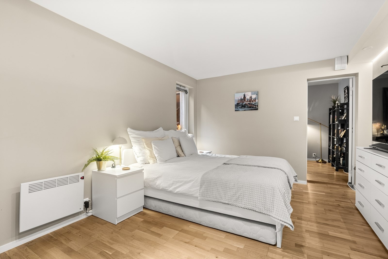 Soverom med god plass til stor dobbeltseng, tilhørende nattbord og garderobeløsning Galleribilde