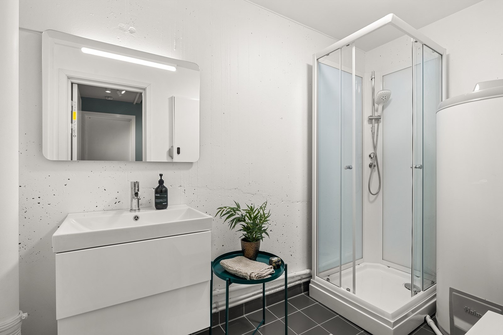 Videre er det også bod innredet med dusjkabinett og servant Galleribilde