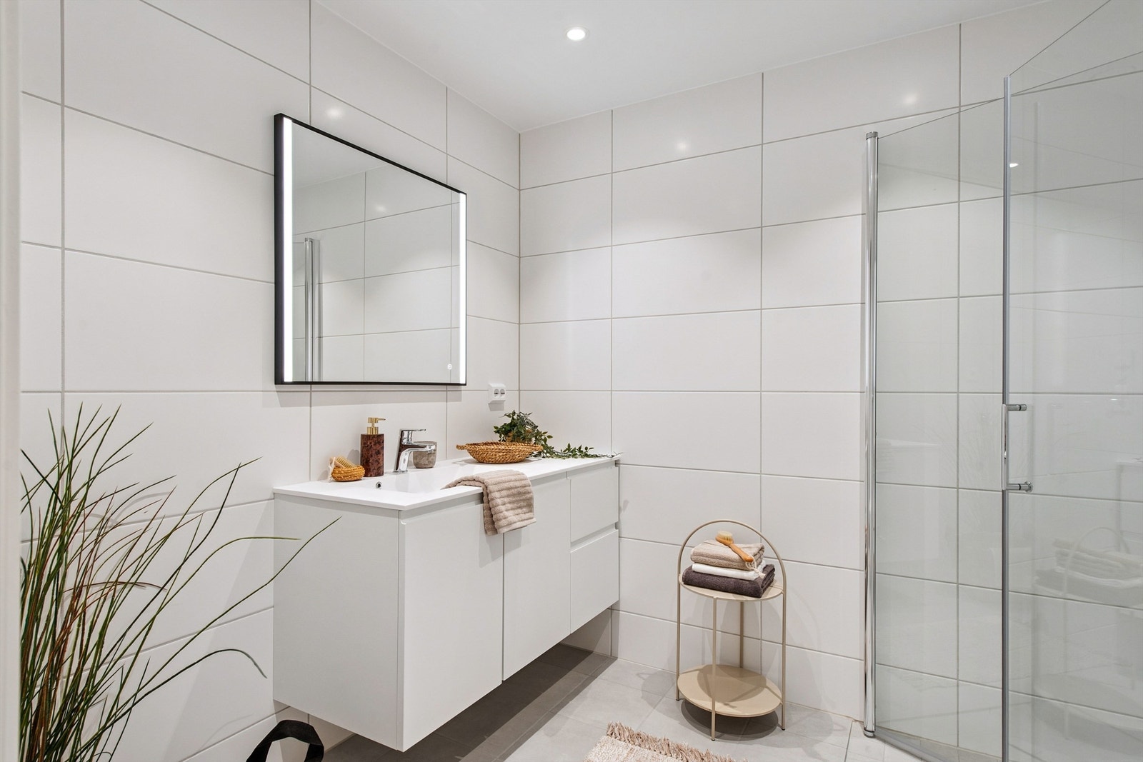 Delikat og moderne bad med klassisk innredning og speil med integrert lys. Stilrene fliser og romslig dusjløsning. Perfekt for den kvalitetsbevisste boligsøker. Galleribilde