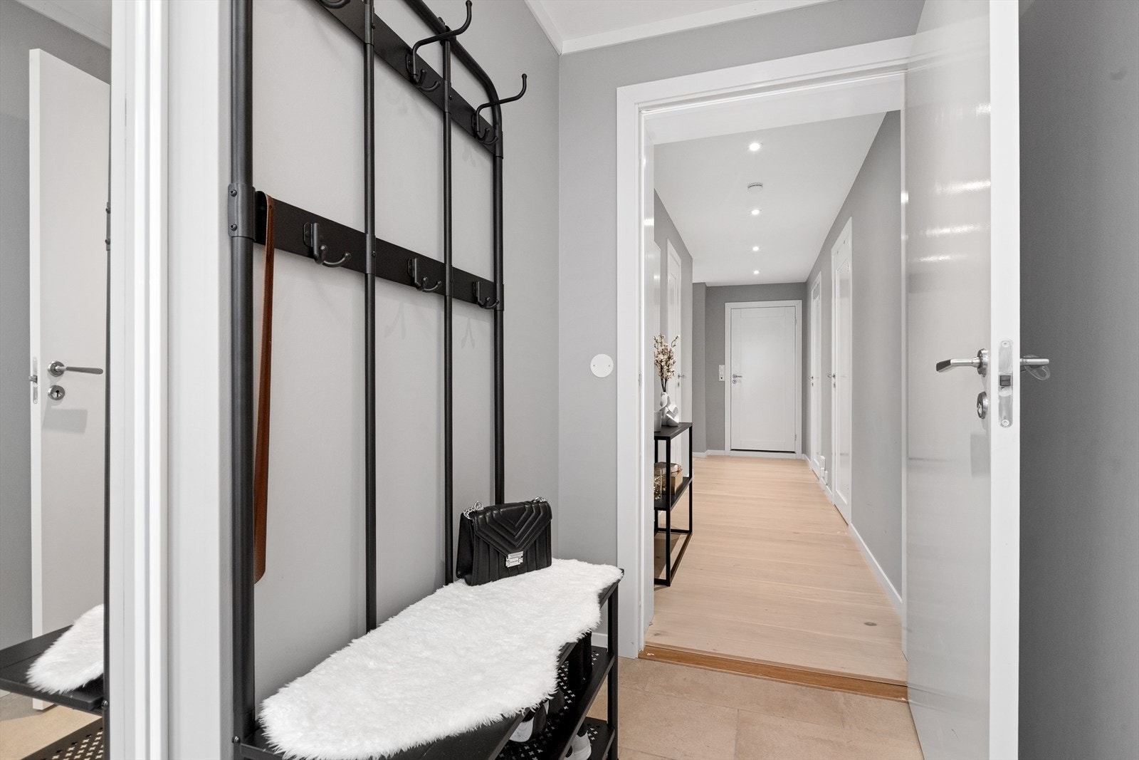 Lys og innbydende entré med flislagt gulv og behagelig gulvvarme - en stilren velkomst til hjemmet Galleribilde