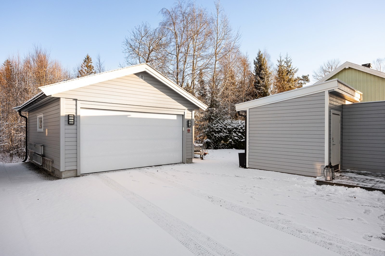 Eiendommen inkluderer en romslig dobbelgarasje og en praktisk bod ved inngangspartiet. Galleribilde