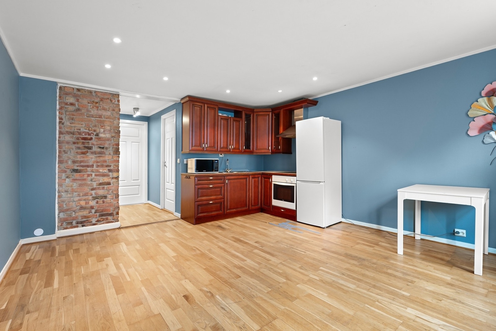 Stue med åpen kjøkkenløsning som er malt i moderne og tidsriktig blåfarge. Galleribilde