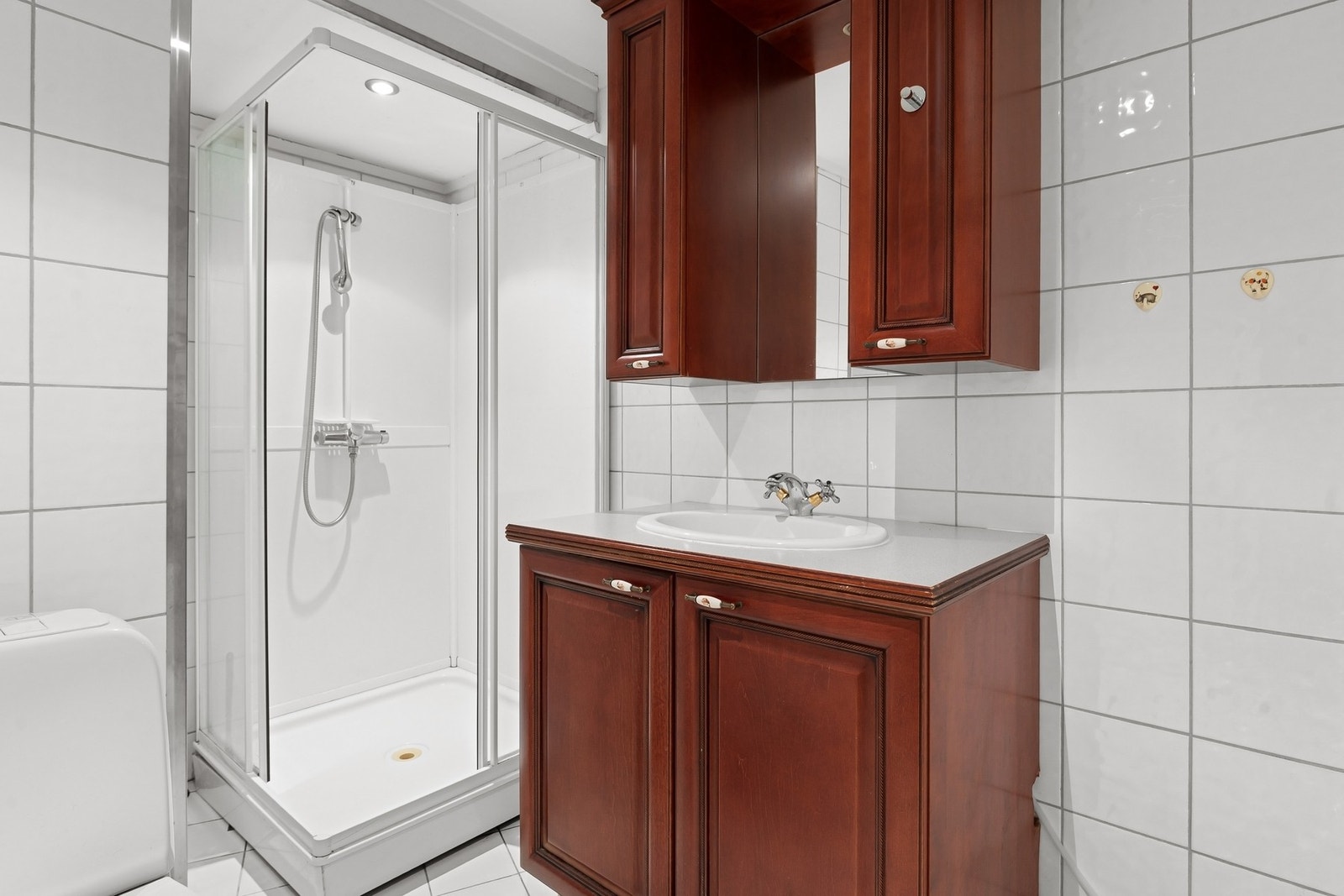 Godt innredet baderom med servantskap, dusjkabinett og WC. Galleribilde