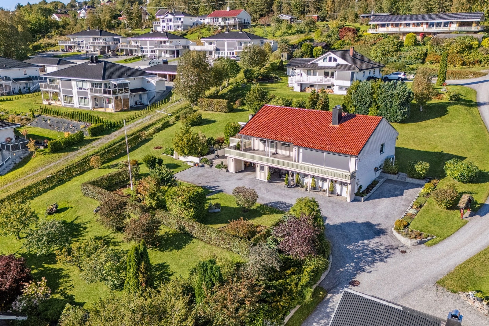 Asfaltert gårdsplass med mye oppstillingsplass og integrert garasje Galleribilde