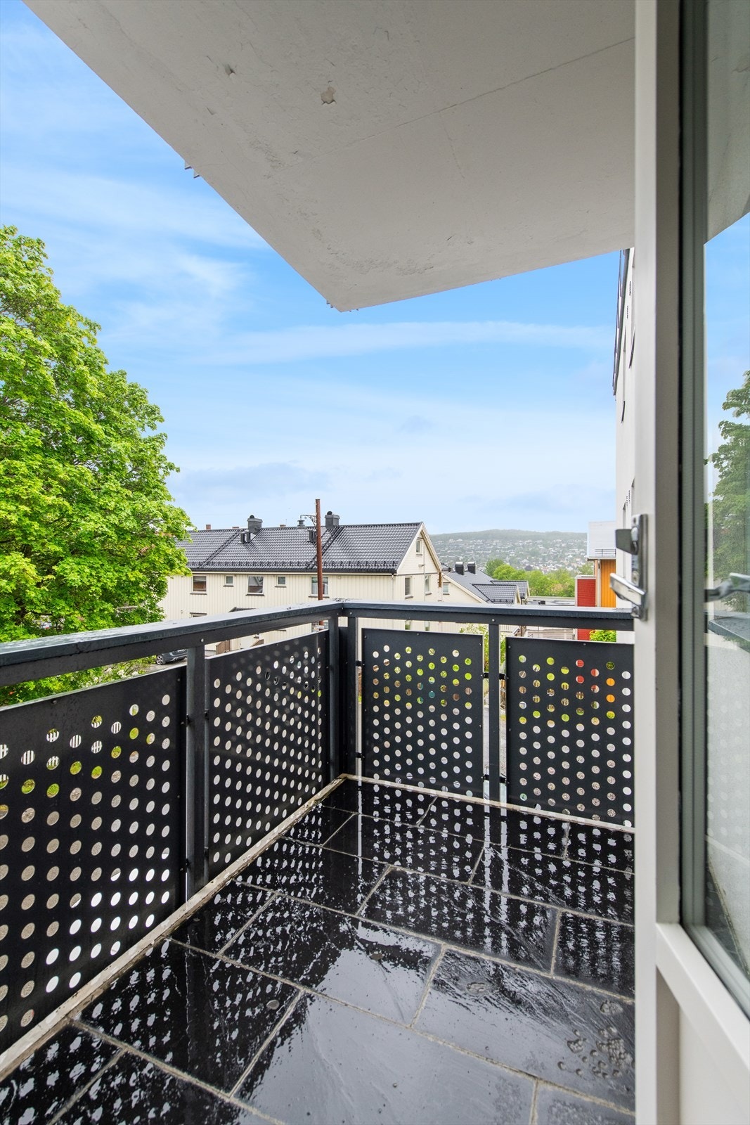 Balkong har fliser på gulv og rekkverk har aluminiumsprofiler. Galleribilde