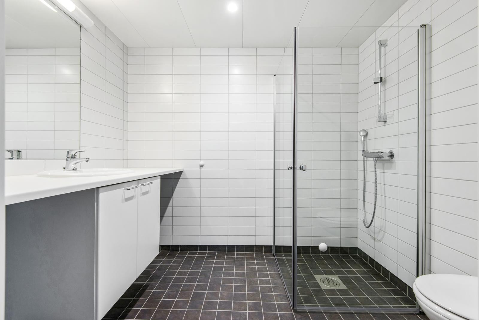 Delikat flislagt baderom med varme i gulv. Opplegg for vaskemaskin. Galleribilde