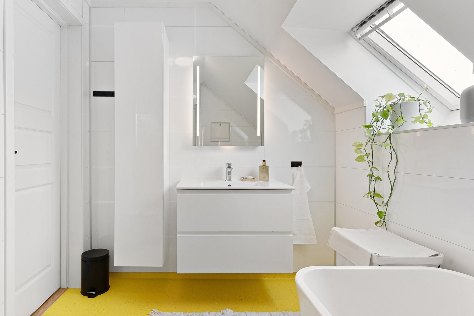 Nyere bad som er innredet med servantskap med tilhørende veggskap, badekar, dusjhjørne og vegghengt wc. Galleribilde