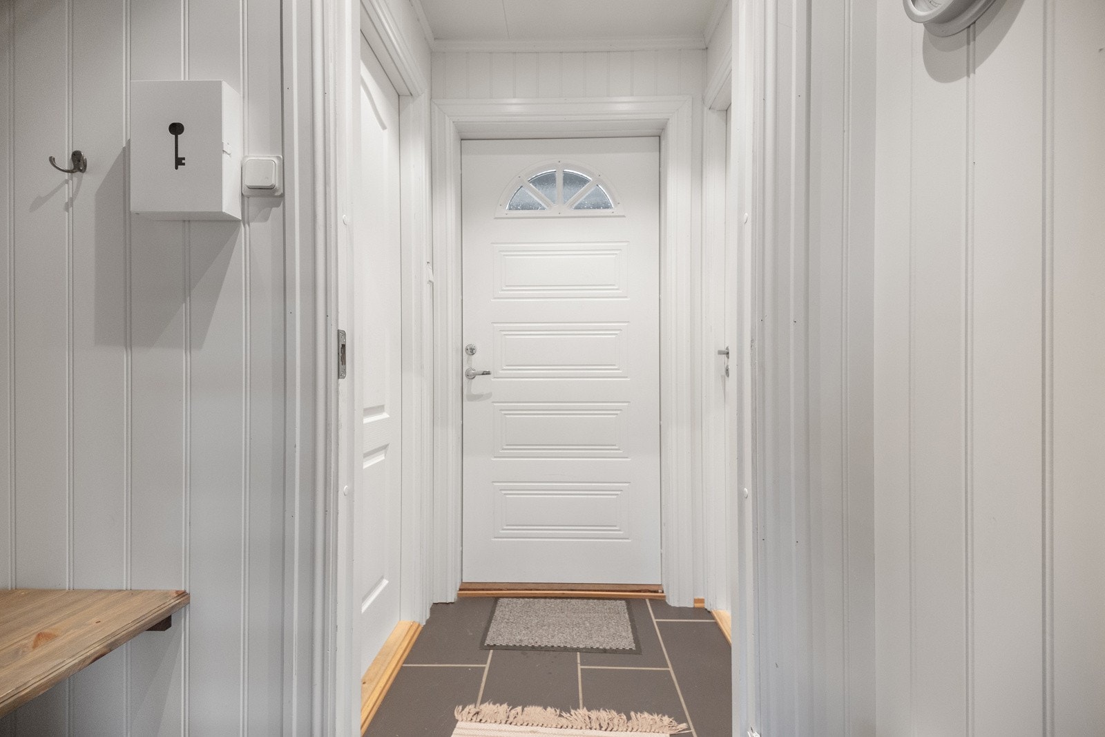 Flislagt entré med plass til å henge fra seg yttertøy og sko Galleribilde