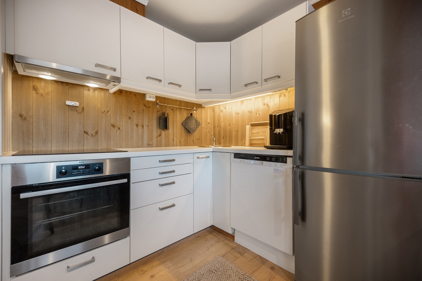 Kjøkkenet inneholder over- og underskap, benkeplate, komfyr fra 2022, induksjonstopp fra 2021, oppvaskmaskin og frittstående kjøleskap Galleribilde