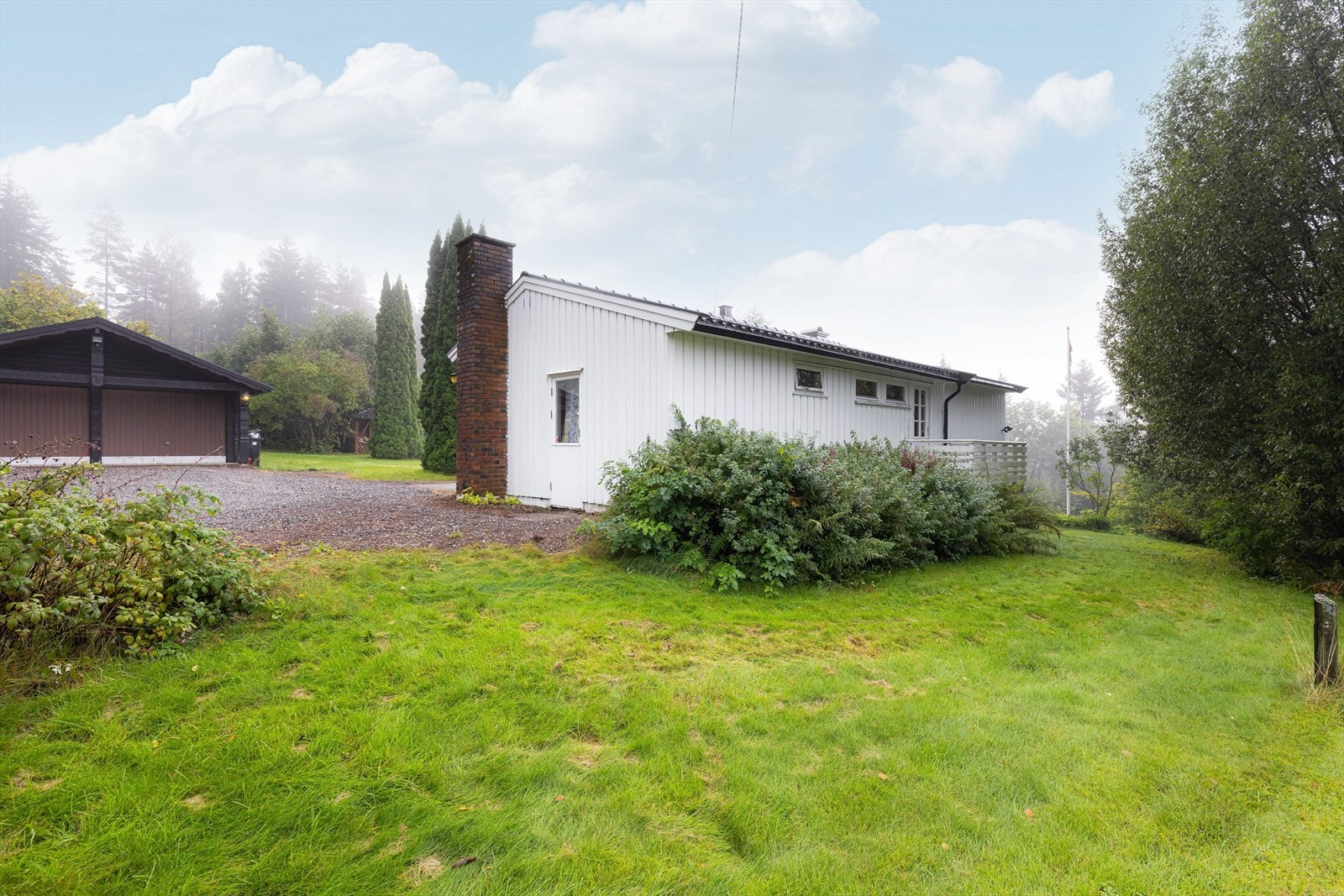 Det er godt med biloppstillingsplasser på gruset gårdsplass, og i dobbel garasje med støpt gulv og leddporter i tre. Galleribilde