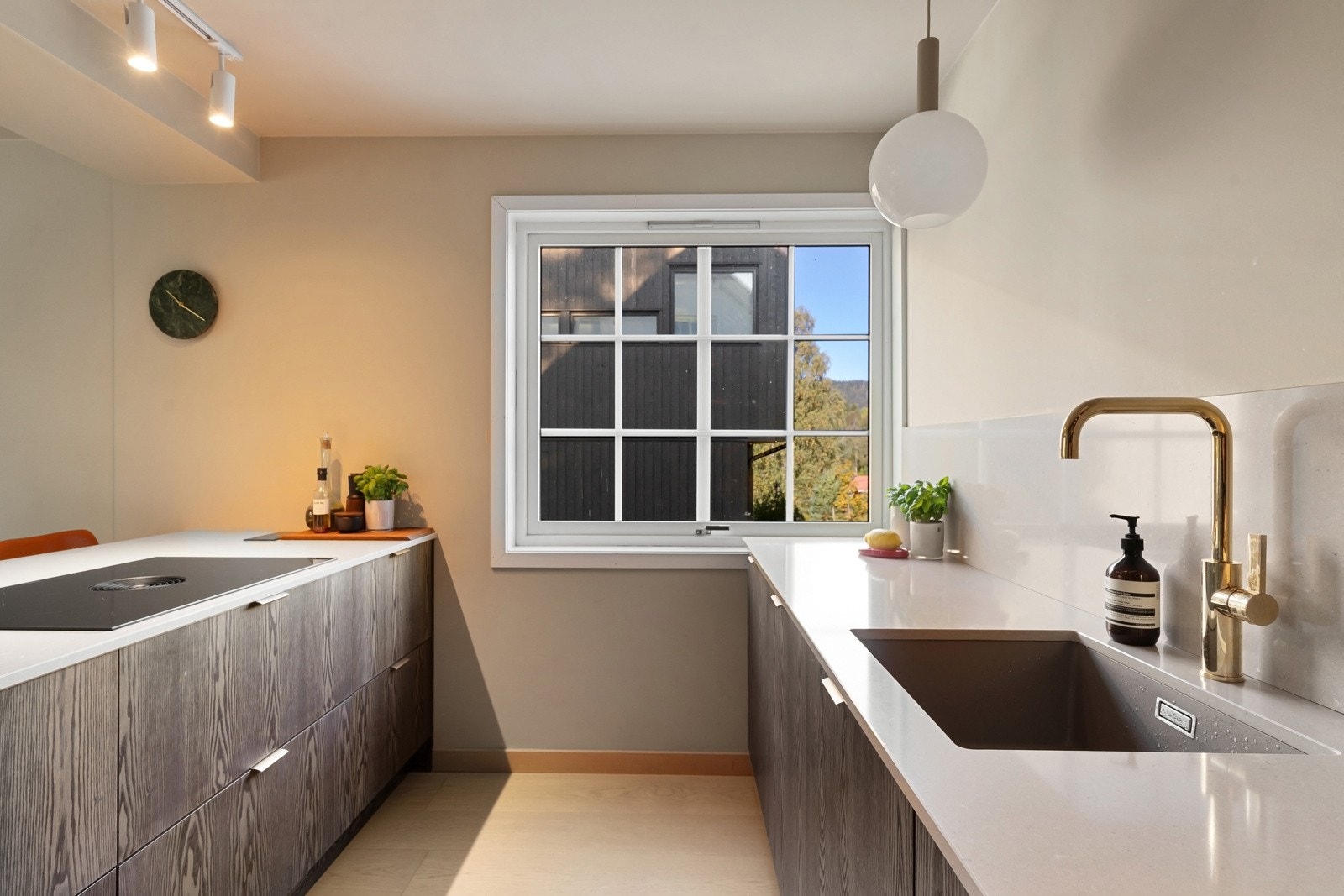 Integrerte hvitevarer fra AEG som induksjonstopp med ventilator, stekeovn, kjøleskap og oppvaskmaskin. Galleribilde