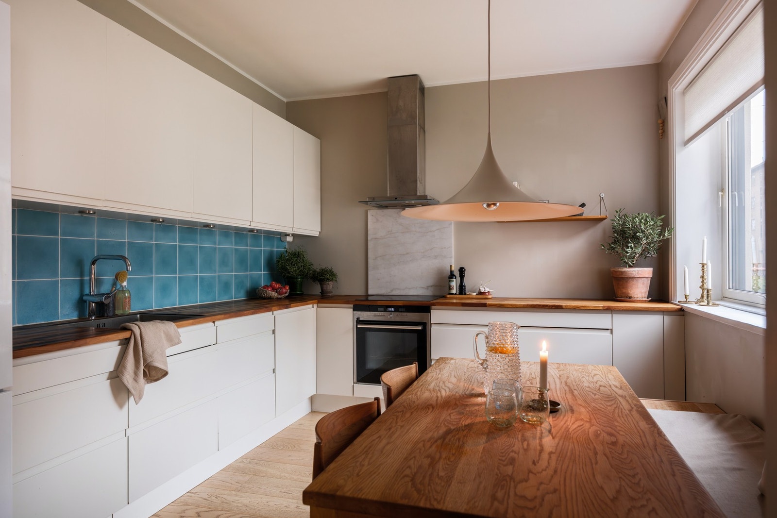 Moderne HTH-kjøkkeninnredning med hvite fronter m/ integrerte grep og downlights. Galleribilde