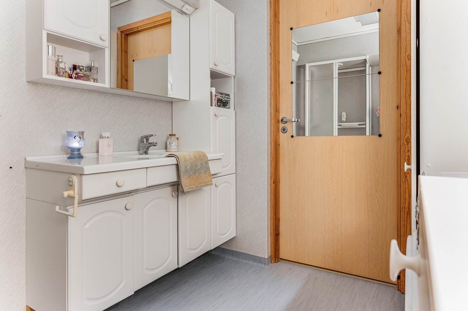 Lys baderomsinnredning med servant og speilskap over. Galleribilde