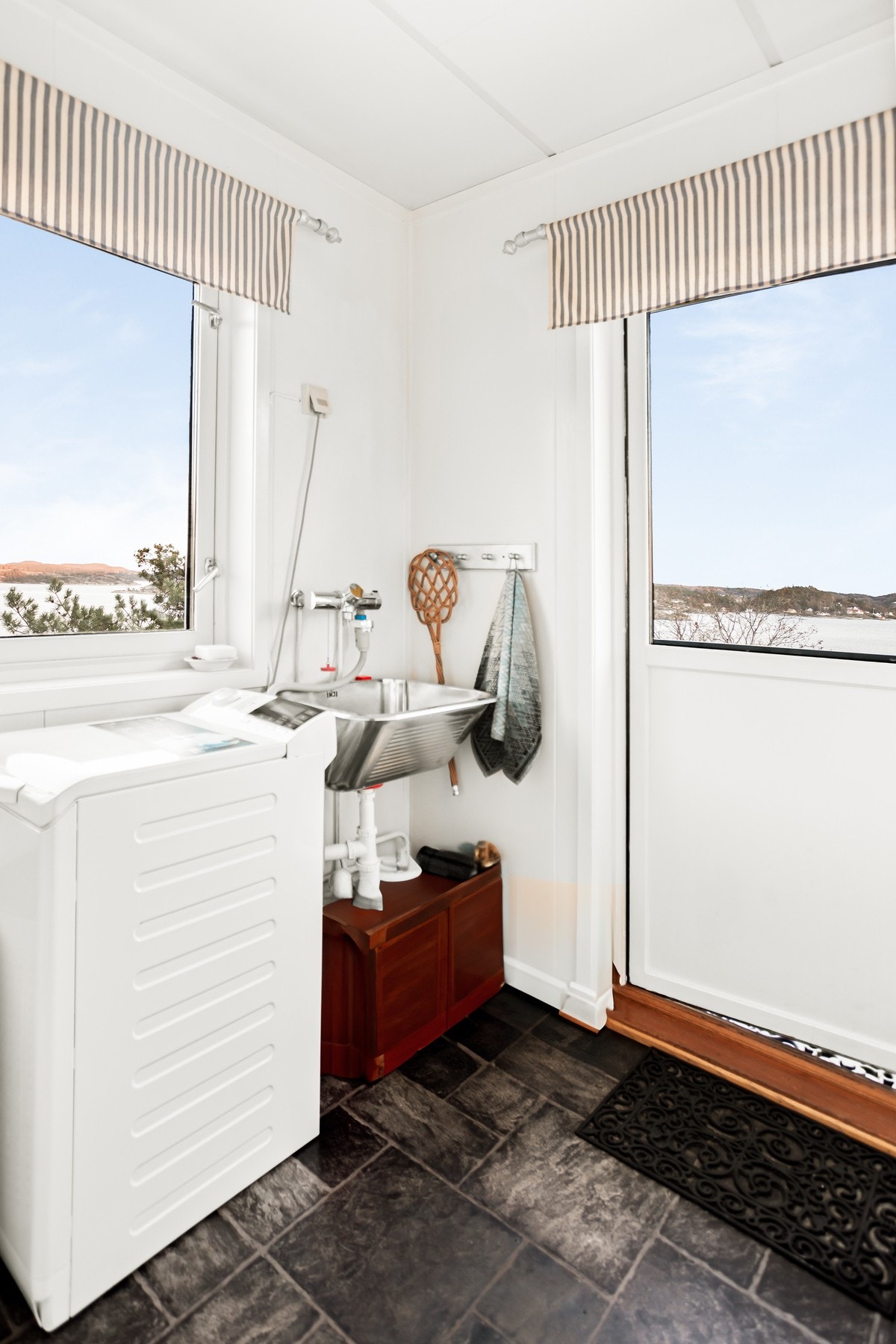 Videre ut fra kjøkkenet kommer du til vaskerommet, med egen utgang ut til terrassen. Galleribilde