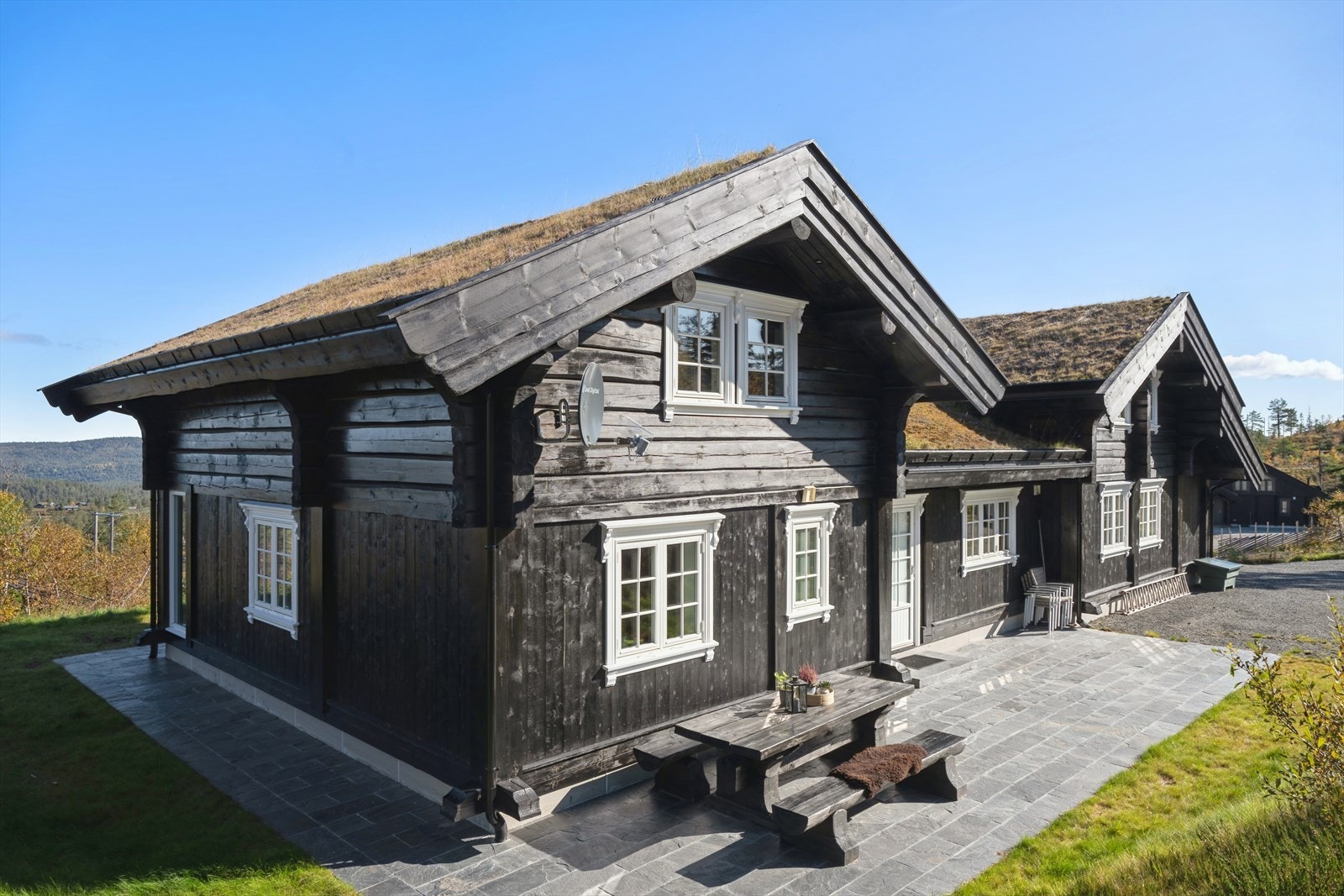 Koselige steinlagte uteplasser på begge sider av hytta gjør at du kan flytte deg etter sol og vindretning. Galleribilde