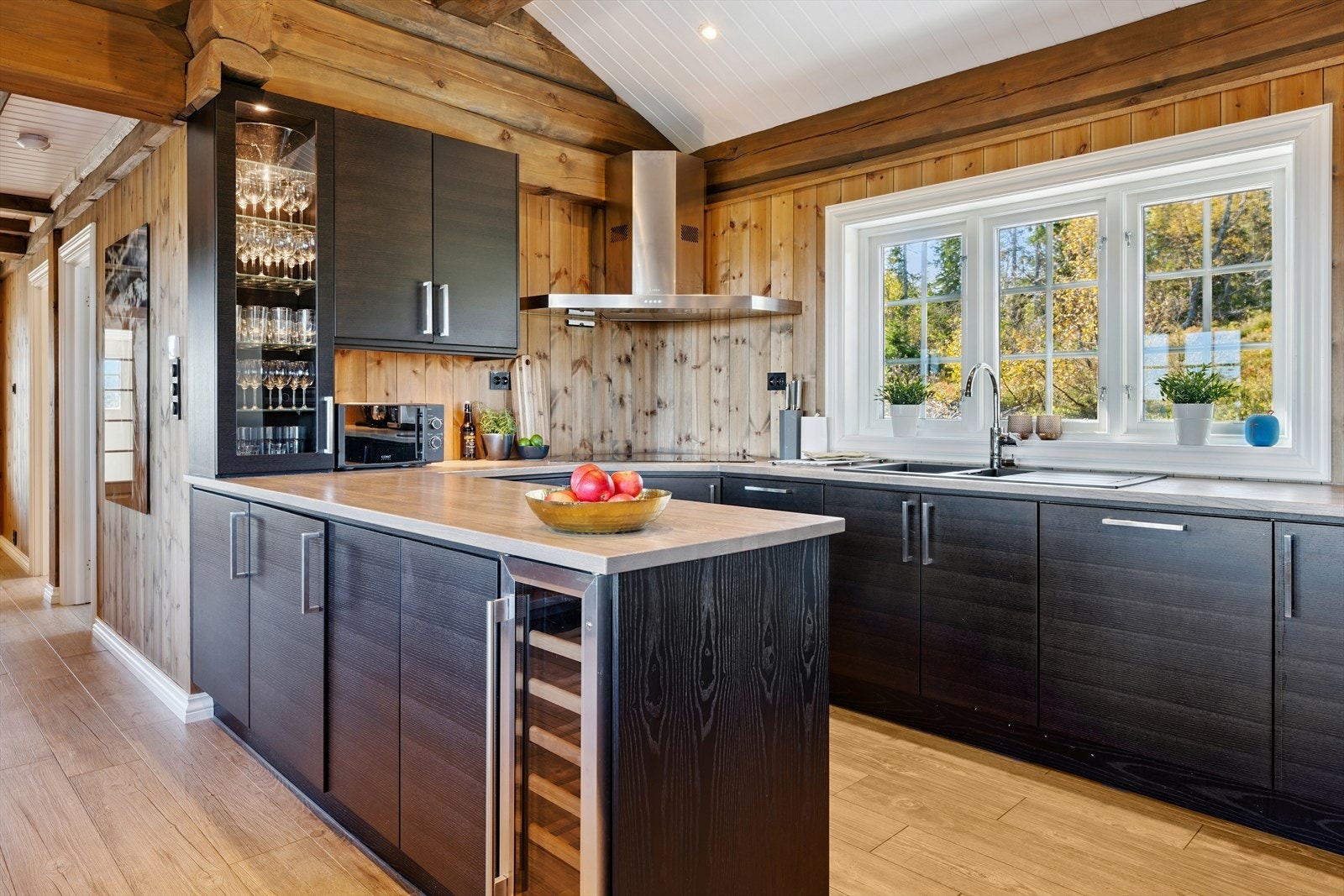 Kjøkkeninnredning fra Drømmekjøkkenet. Kjøkkenet er utstyrt med kjøleskap, oppvaskmaskin, 2 stekeovner, induksjonstopp og vinskap. Galleribilde