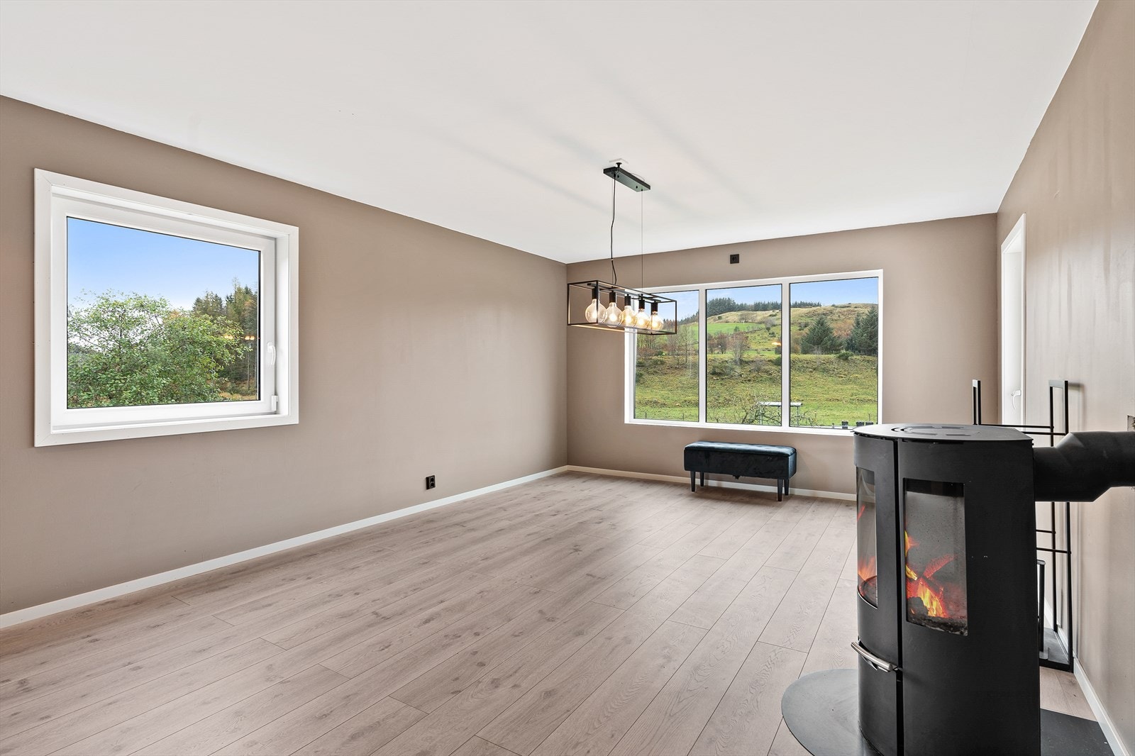 Trivelig stue malt i en moderne jordfarge med enstavs laminat på gulv Galleribilde