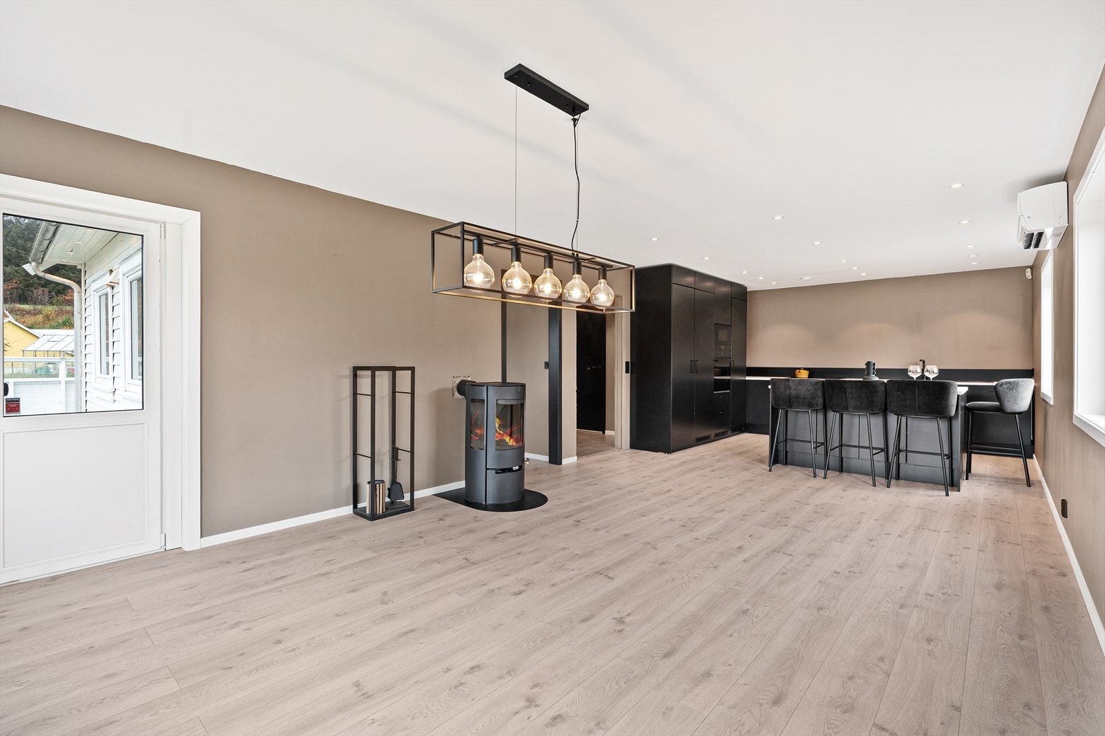 Åpen stue-kjøkkenløsning med god plass til sofagruppe og spisebord Galleribilde