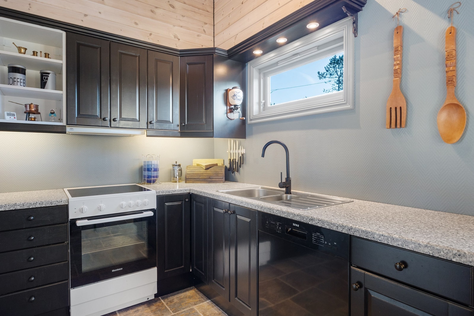 Pent hyttekjøkken med oppvaskmaskin samt god skap- og benkeplass Galleribilde