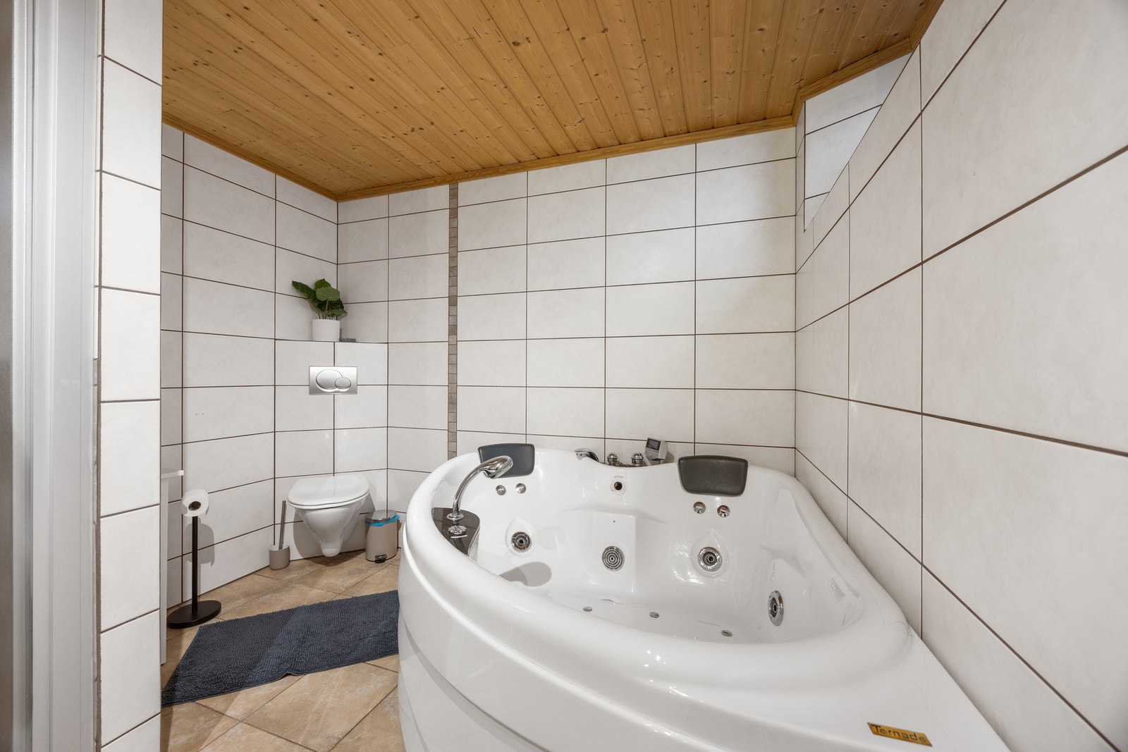 Utstyrt med toalett, hjørnekar, dusj, servantskap og opplegg for vaskemaskin Galleribilde