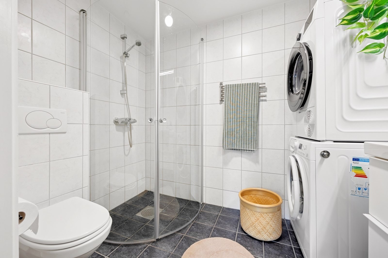 Badet måles til 3,8 kvm. og er helfliset med en slett malt himling. Det er innredet med vegghengt toalett, dusj med glassvegger og baderomsinnredning med speil og belysning. Galleribilde