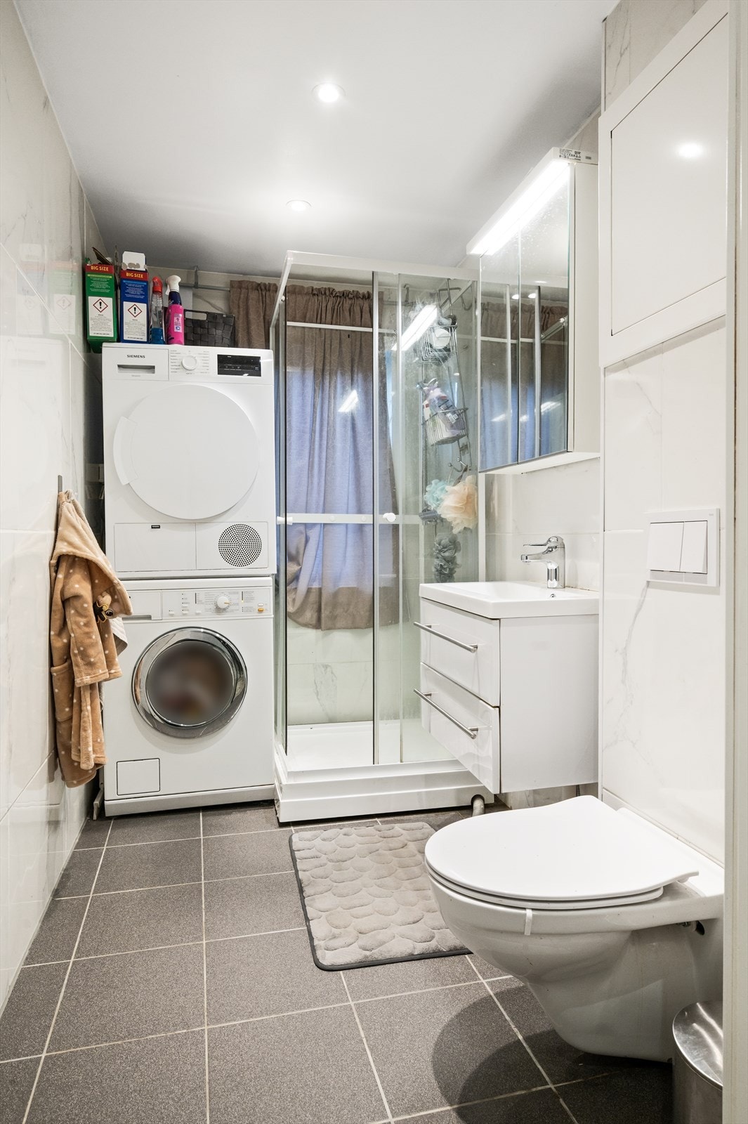 Videre er badet innredet med dusjkabinett. Det er også opplegg for vaskemaskin. Galleribilde