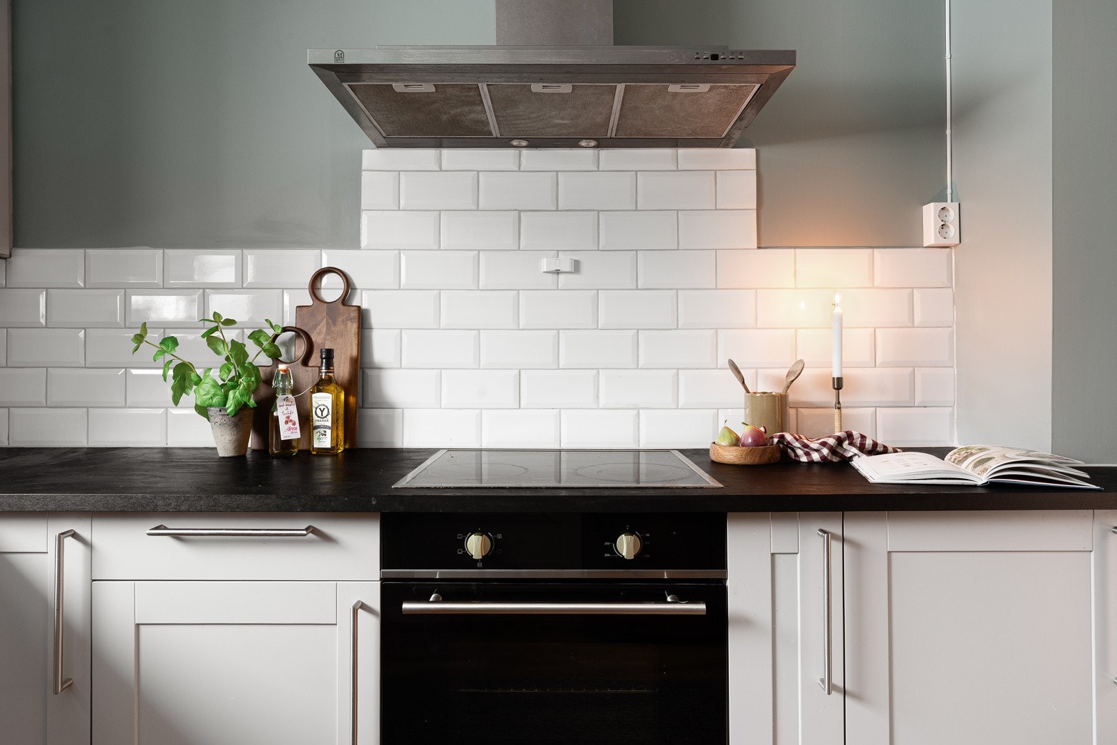 Delikat kjøkken med innredning med profilerte fronter og fliser over benk. Galleribilde