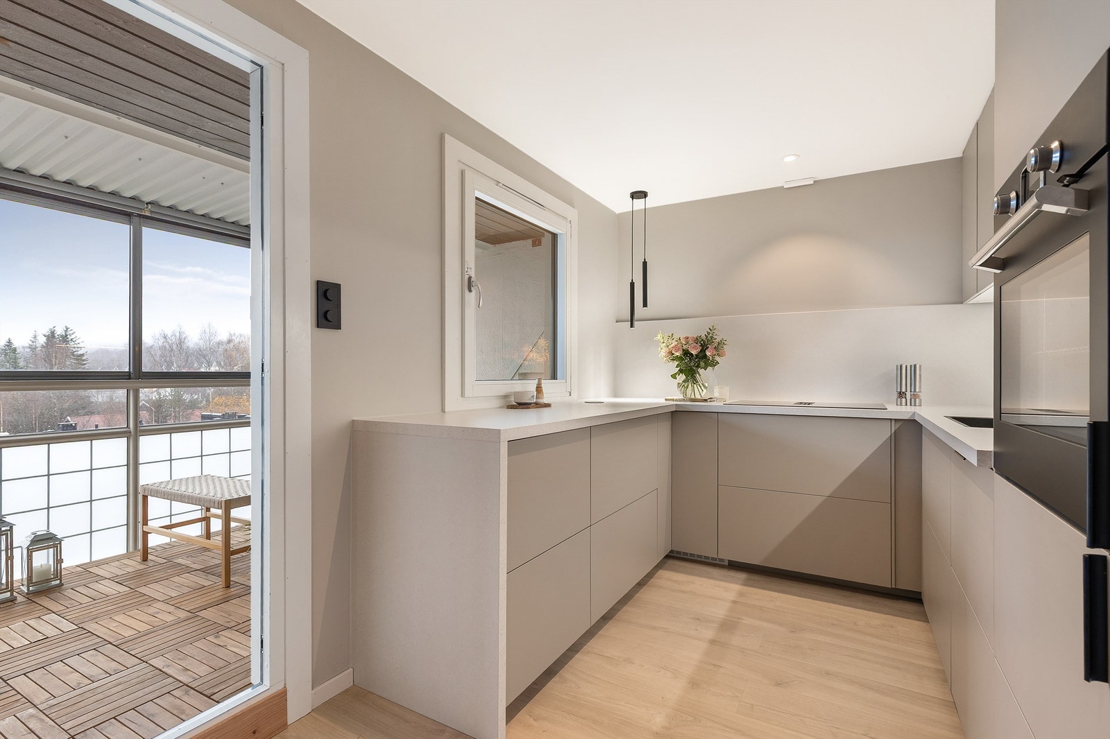 Kjøkkenet er moderne og stilrent med glatte fronter og laminat benkeplate med planlimt vaskekum. Herfra er det utgang til boligens herlige balkong. Galleribilde