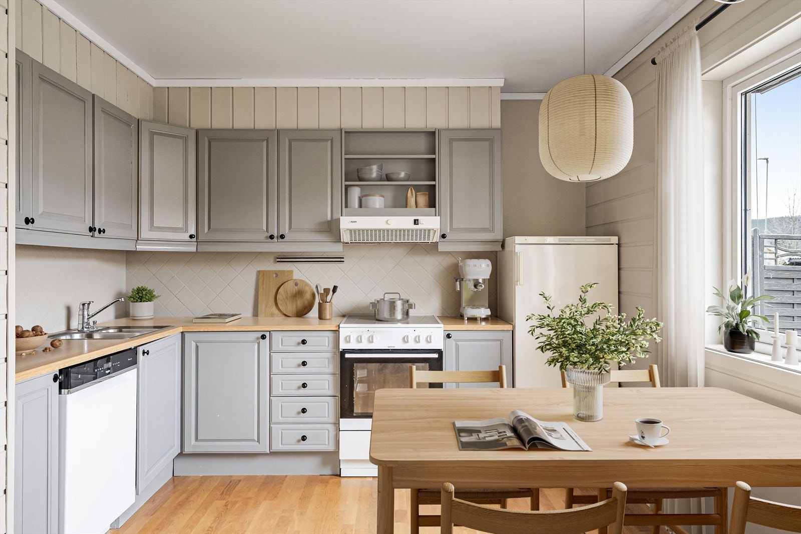 Kjøkken med åpen løsning for hvitevarer og plass til spisebord (bildet er digitalt stylet). Galleribilde