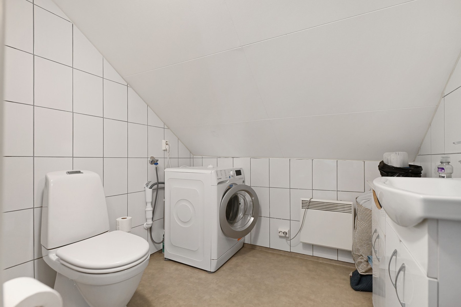 Badet i 2. etasje er fra 2018. Rommet har innredning med nedfelt servant, toalett, dusjnisje og opplegg for vaskemaskin. Galleribilde