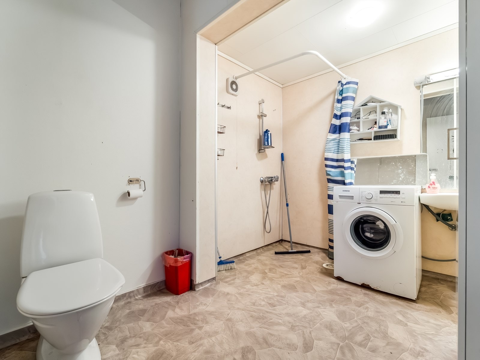 Bad med dusj, toalett og plass til vaskemaskin. Galleribilde
