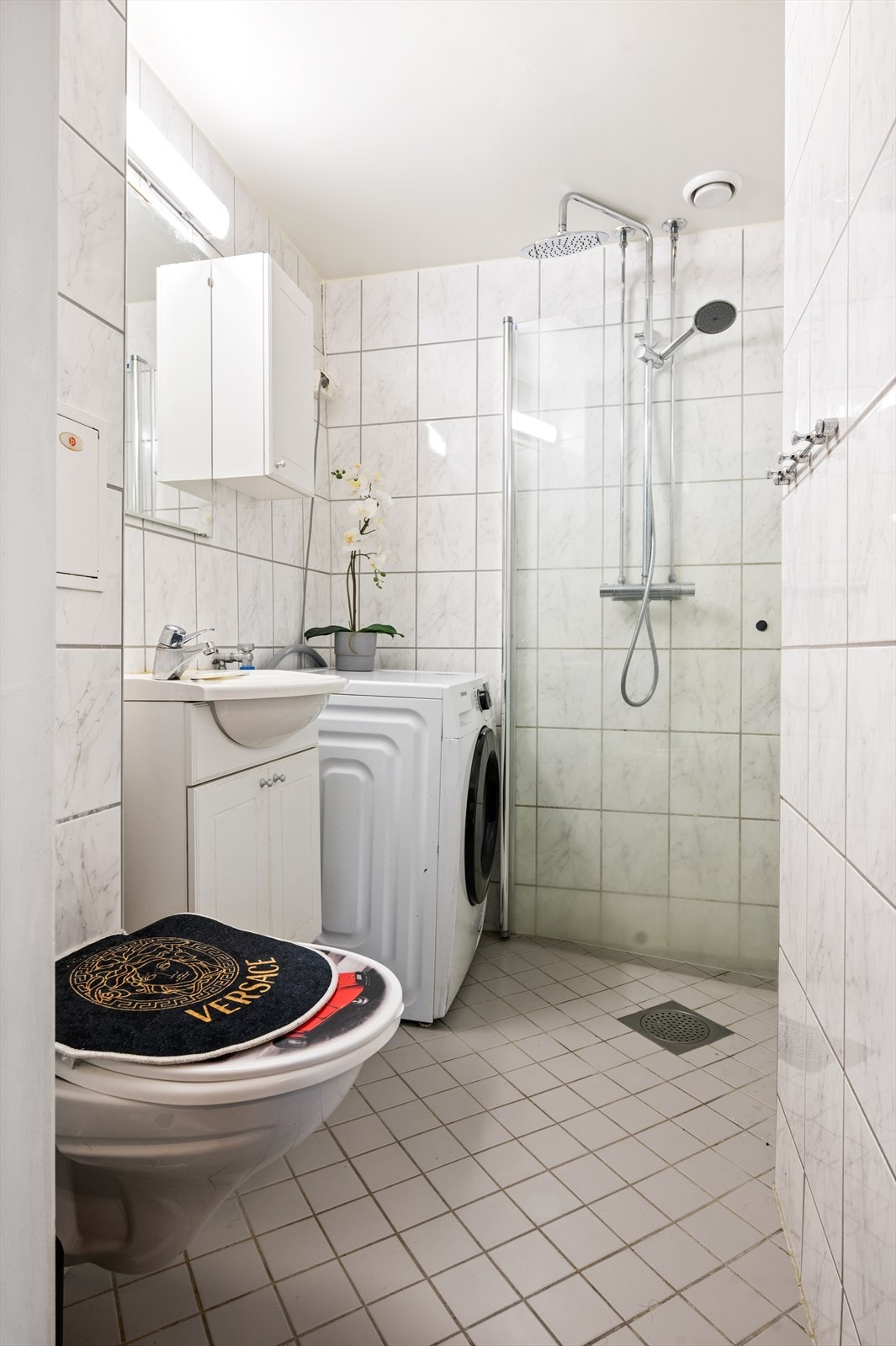 Videre har badet dusjhjørne og vegghengt klosett. Det er opplegg for vaskemaskin. Galleribilde