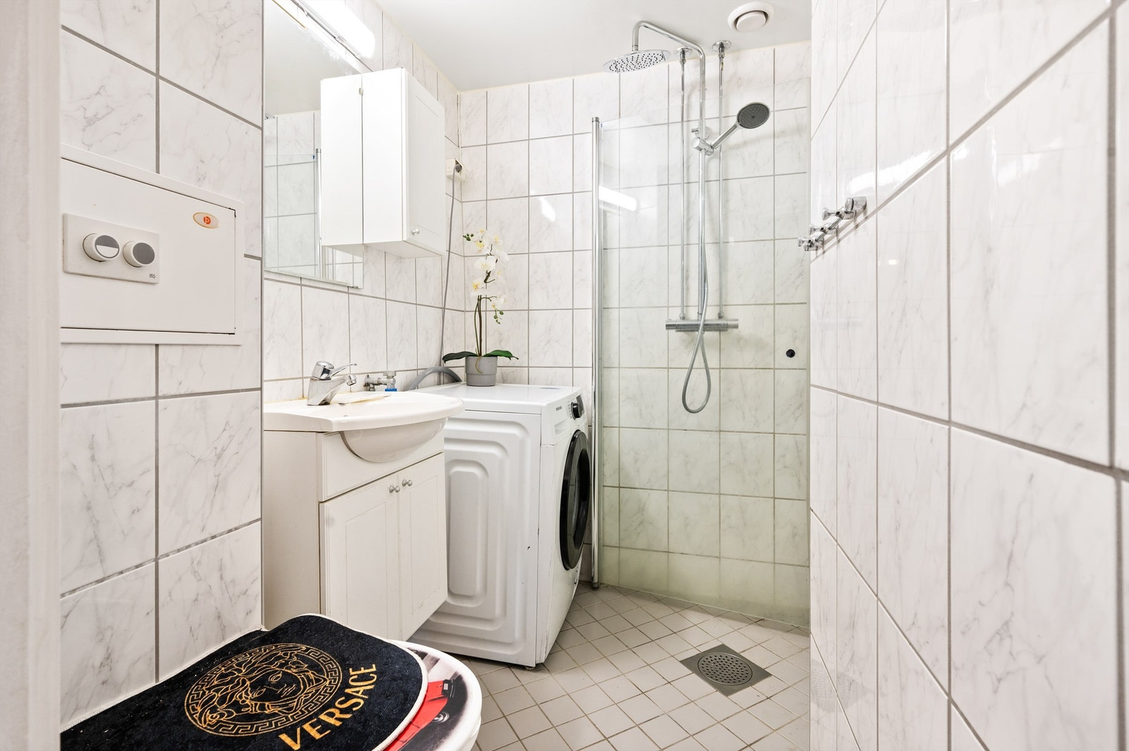 Badet er flislagt på gulv og vegger med varme i gulvet. Baderomsinnredningen består av veggehengt servantinnredning med servant. Galleribilde