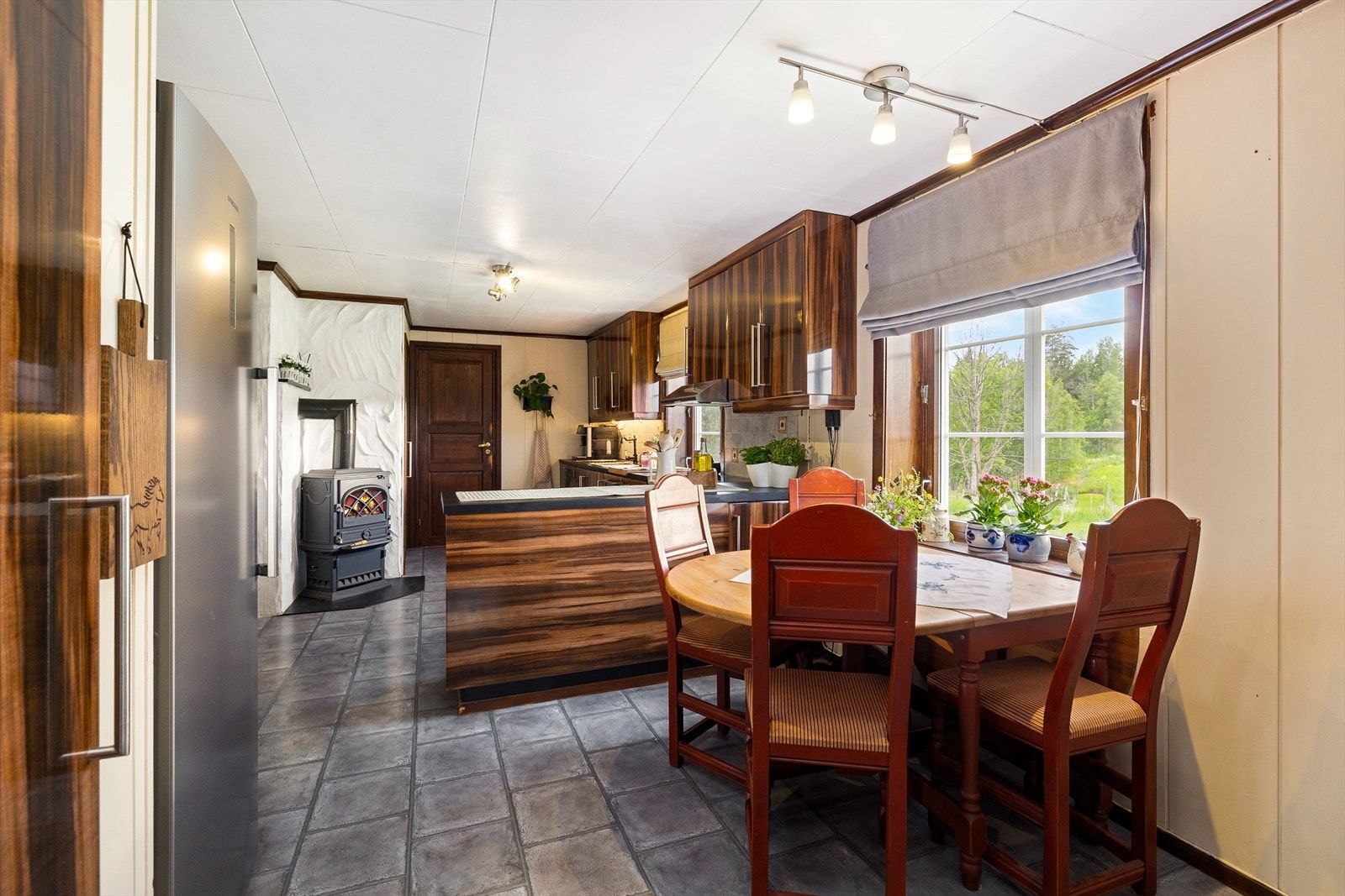 På kjøkkenet er det plass til spisebord ved vinduet med utsikt mot jorder og skog. Galleribilde