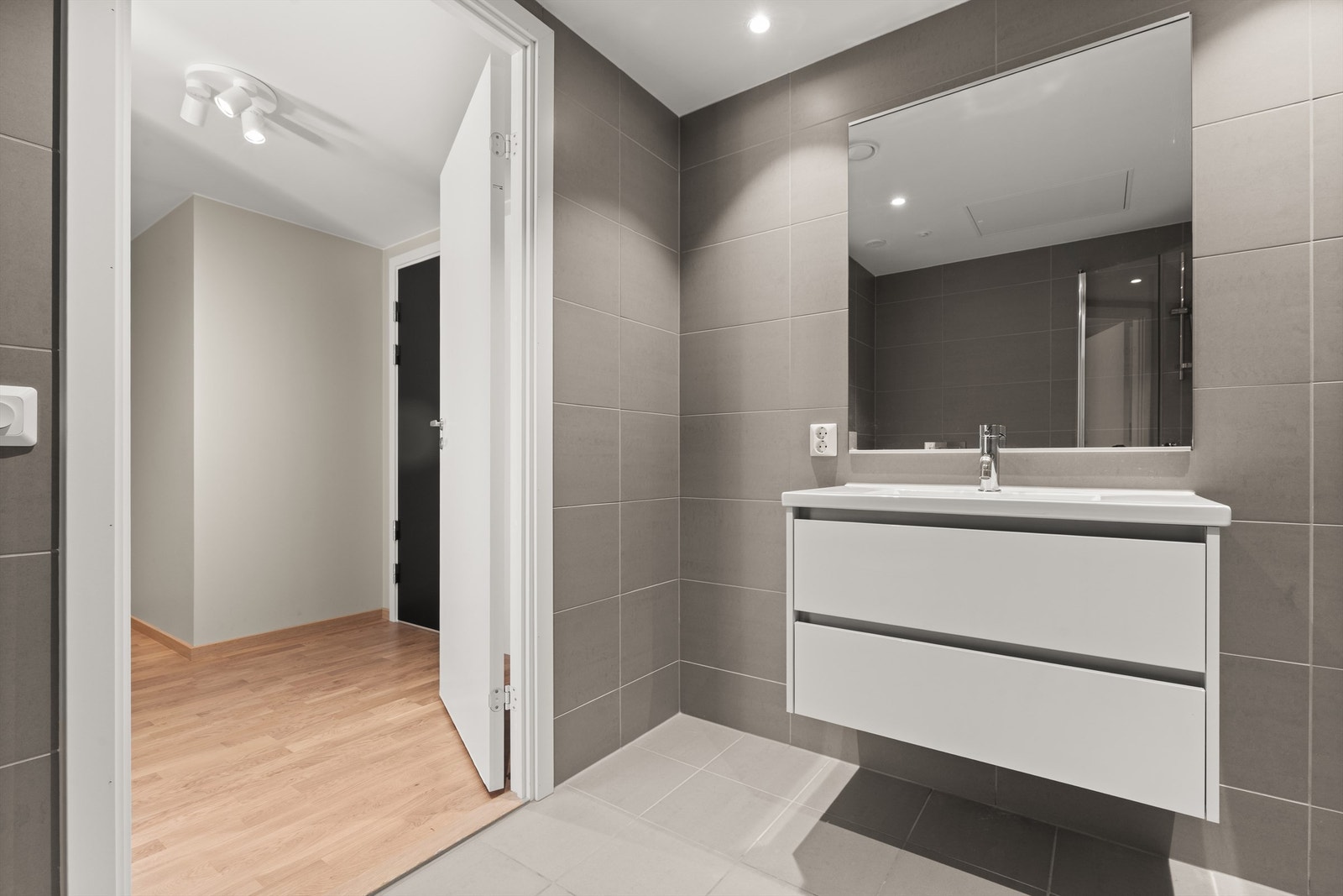 Pent flislagt bad med varme i gulvet. Baderomsinnredningen består av vegghengte servantskuffer med nedfelt servant. Galleribilde