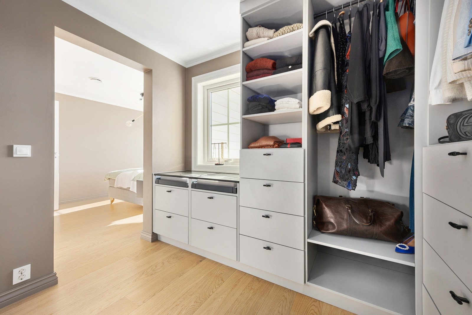 Plassbygd walk in fra Oslo kjøkkenstudio fra 2021. Innredet med skuffer, hyller, klesoppheng og smykkemonter. Galleribilde