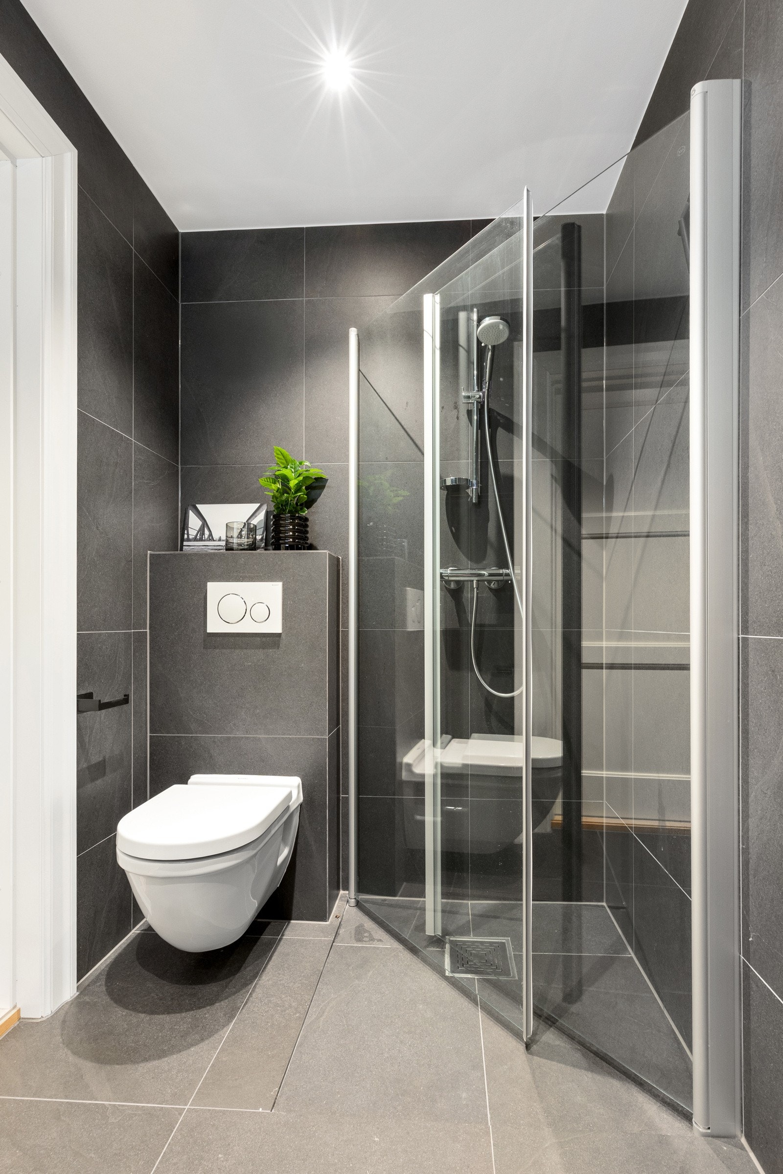 Kjellerbadet er innredet med downlights, dusjhjørne og vegghengt toalett. Galleribilde