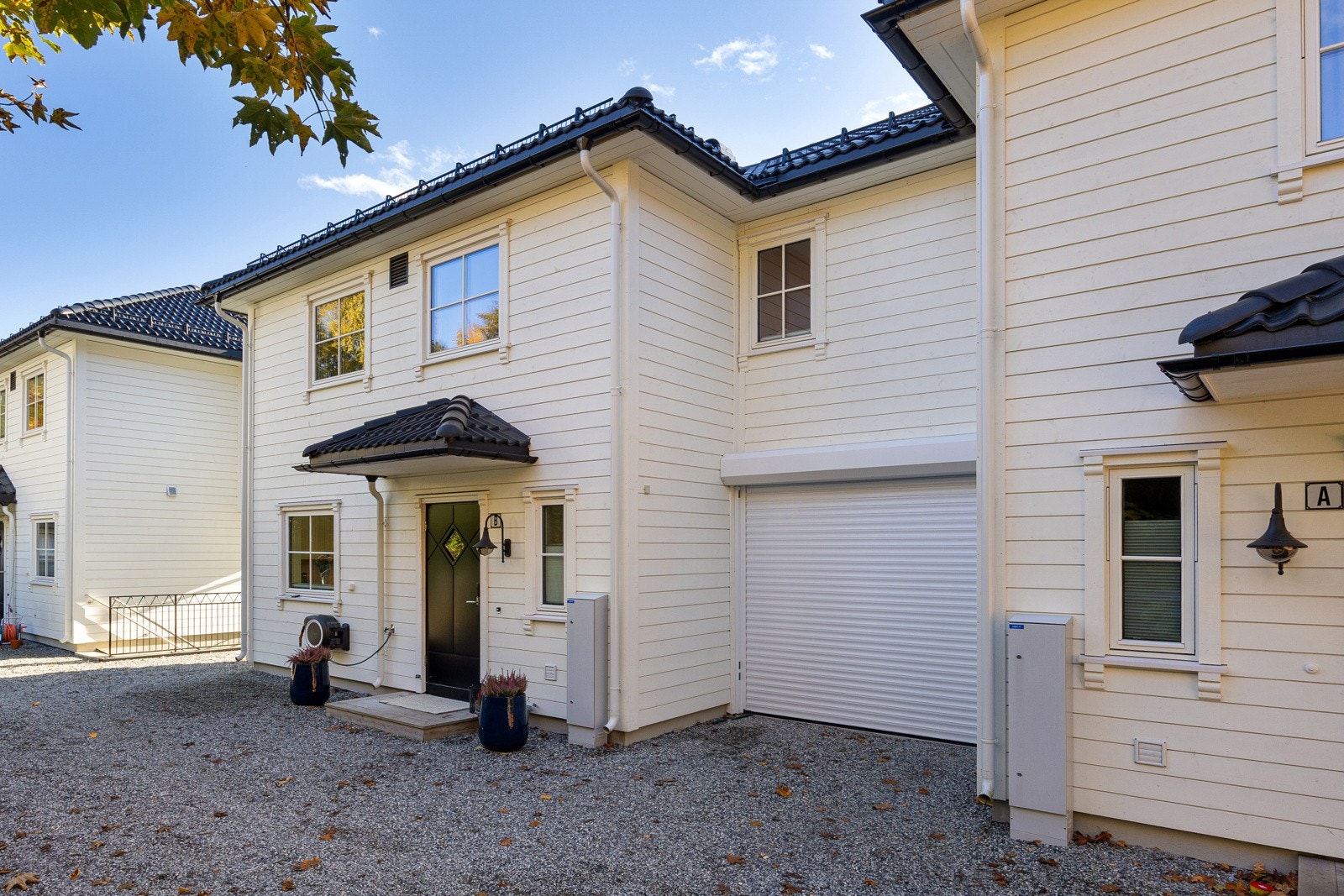 Ved inngangen har boligen to garasjerom med bilheis mellom. Galleribilde